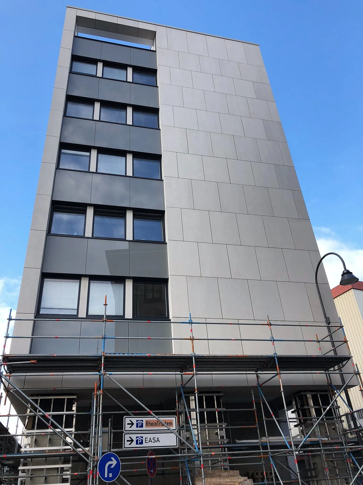 Bürohochhaus der DEVK in Köln im Bauzustand mit Gerüst, hellen großformatigen Fassadenplatten und dunklen Fensterbändern