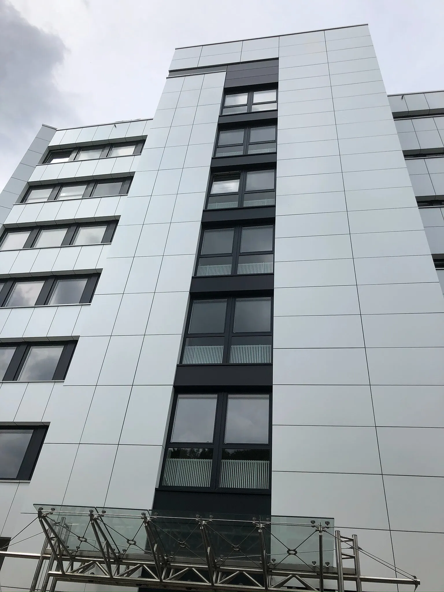 Bürogebäude der DEVK in Wuppertal mit hellen großformatigen Fassadenplatten und vertikalem dunklem Fensterband