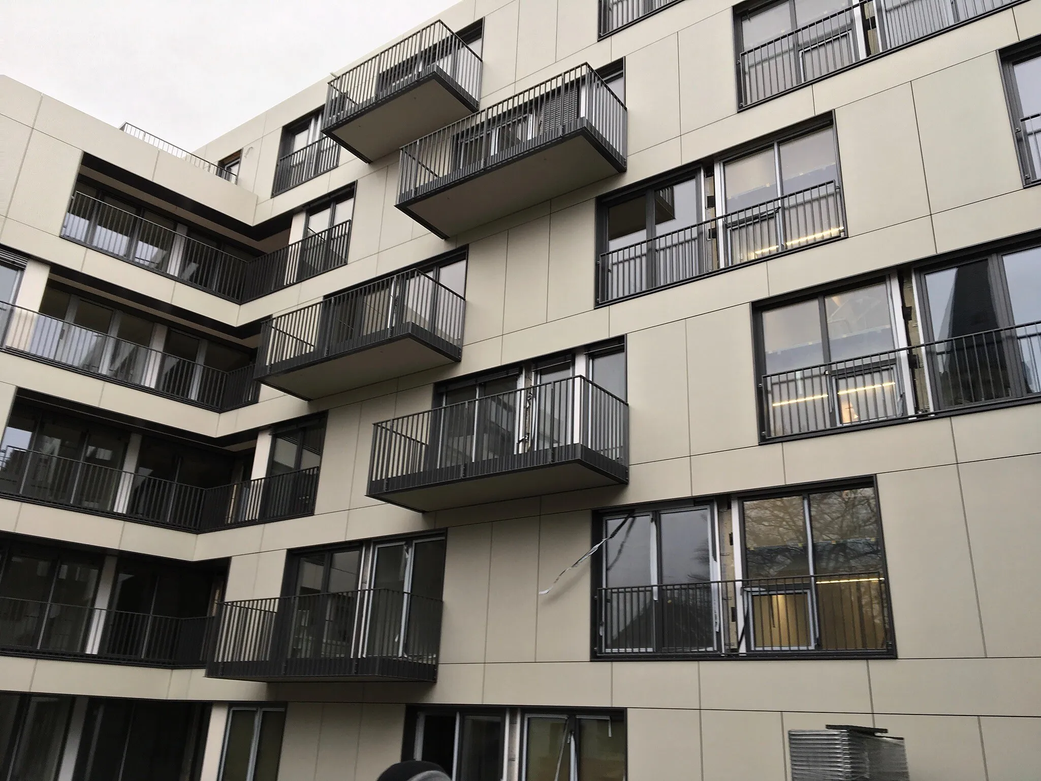 Wohngebäude am Veltmannplatz in Aachen mit heller Plattenfassade und auskragenden Balkonen
